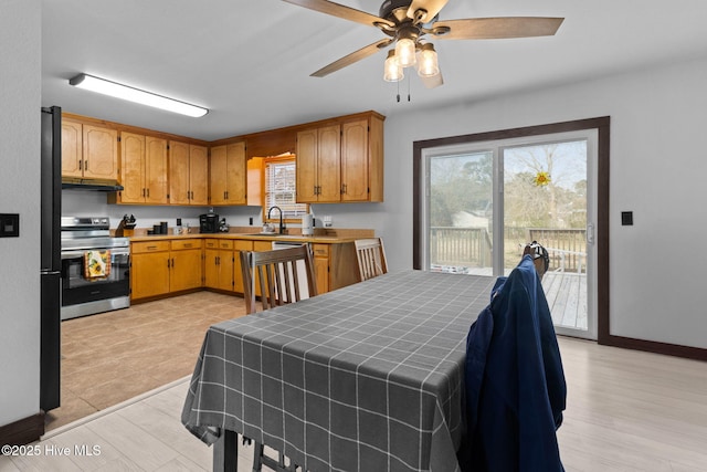 interior space with under cabinet range hood, stainless steel electric stove, dishwashing machine, a ceiling fan, and a sink