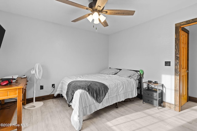 bedroom with a ceiling fan, baseboards, and wood finished floors