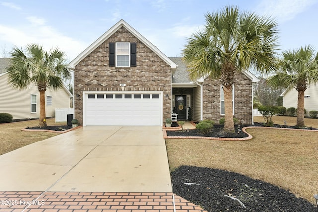 traditional home featuring a garage, a front yard, brick siding, and driveway