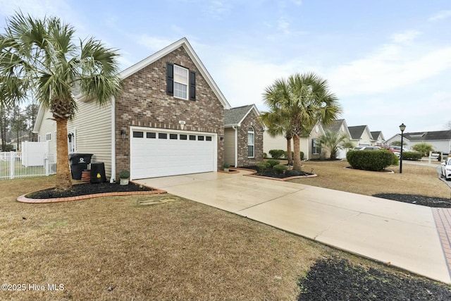 traditional home featuring brick siding, an attached garage, fence, driveway, and a front lawn