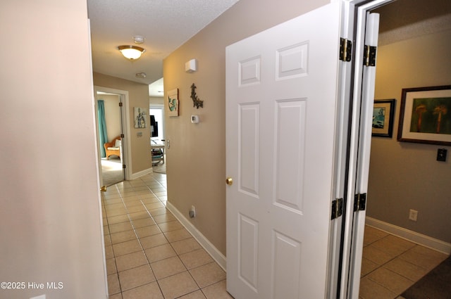 hall with light tile patterned floors and baseboards