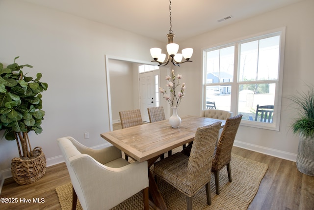 dining area featuring hardwood / wood-style flooring and a notable chandelier