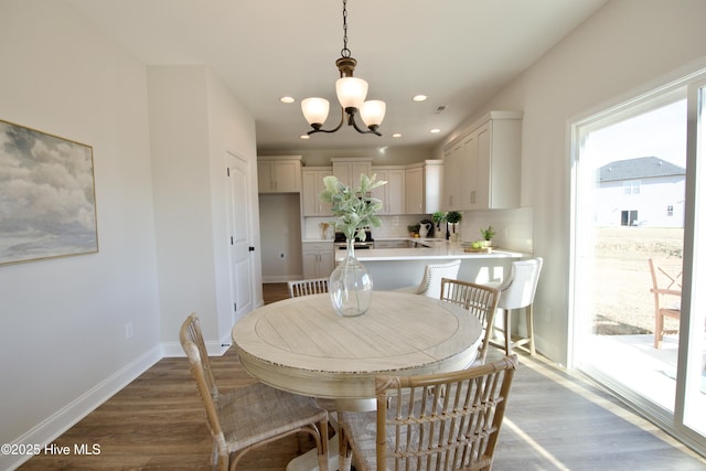 dining area with hardwood / wood-style flooring and a notable chandelier