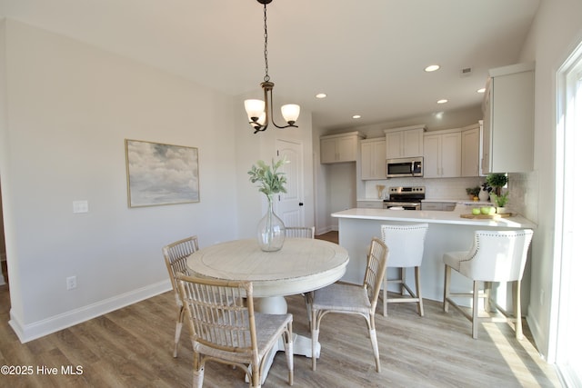 dining area featuring a chandelier and light hardwood / wood-style flooring