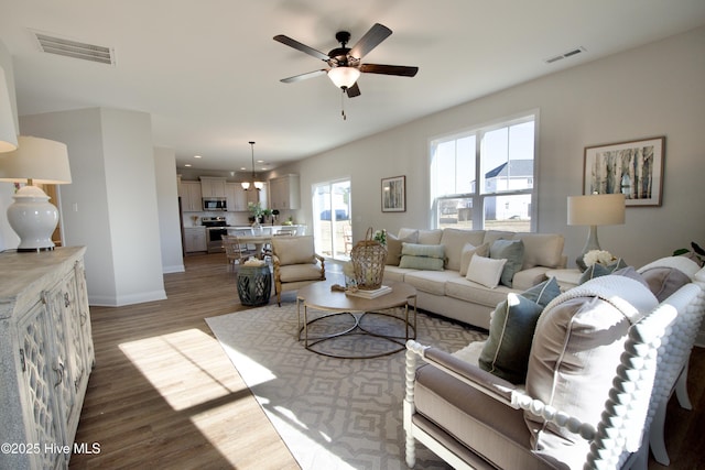 living room featuring dark wood-type flooring and ceiling fan