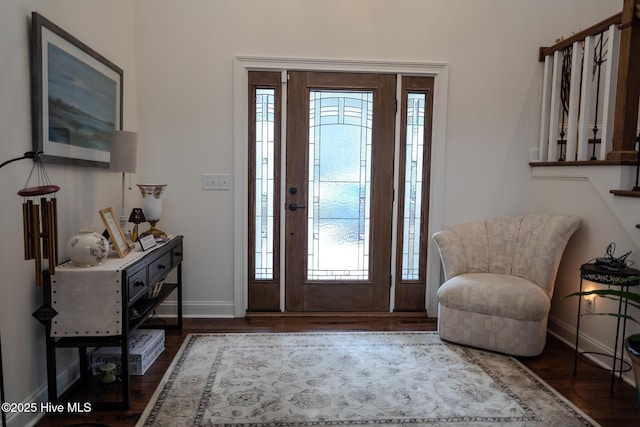 foyer entrance with dark wood finished floors and baseboards