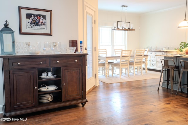 interior space with a notable chandelier, wood finished floors, and crown molding