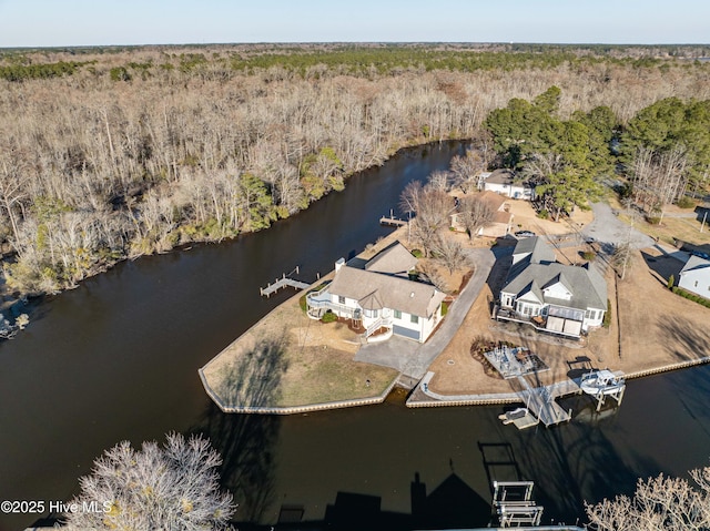 birds eye view of property featuring a wooded view and a water view