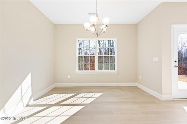 unfurnished room featuring visible vents, baseboards, light wood-type flooring, and an inviting chandelier