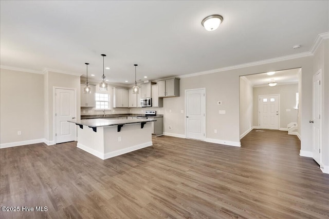 kitchen with a kitchen bar, a center island, appliances with stainless steel finishes, and dark wood-type flooring