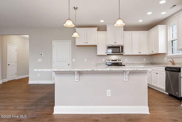 kitchen with appliances with stainless steel finishes, dark wood-style flooring, white cabinetry, and recessed lighting