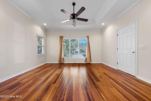 unfurnished room featuring ceiling fan, hardwood / wood-style flooring, a tray ceiling, and ornamental molding