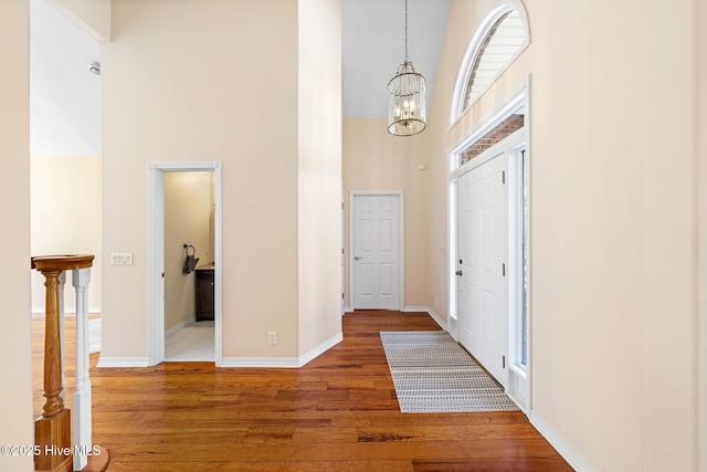 entryway featuring a high ceiling, hardwood / wood-style floors, and a notable chandelier