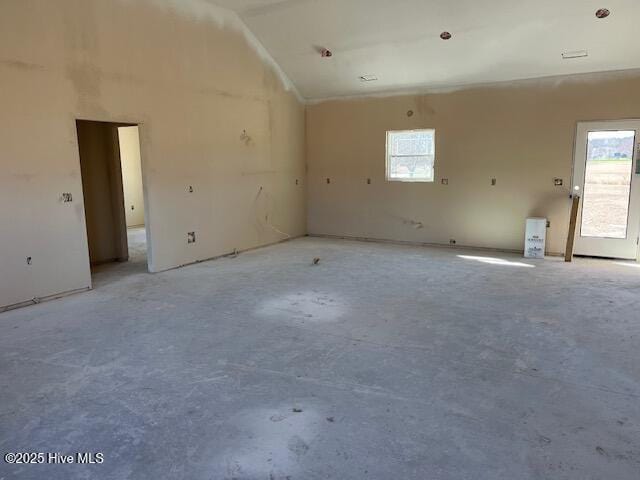 unfurnished room with high vaulted ceiling