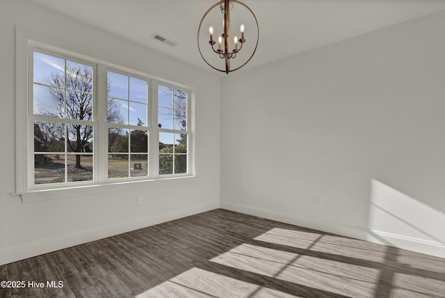 unfurnished room with baseboards, visible vents, a chandelier, and wood finished floors