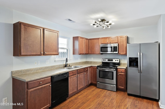 kitchen with sink, stainless steel appliances, and wood-type flooring