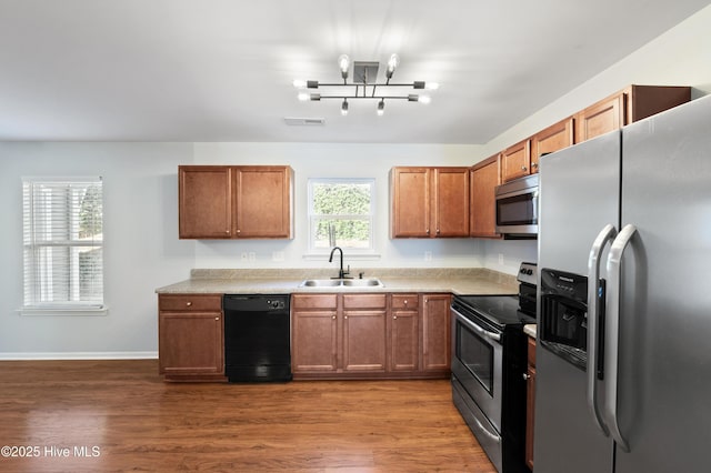 kitchen featuring appliances with stainless steel finishes, sink, and dark hardwood / wood-style flooring