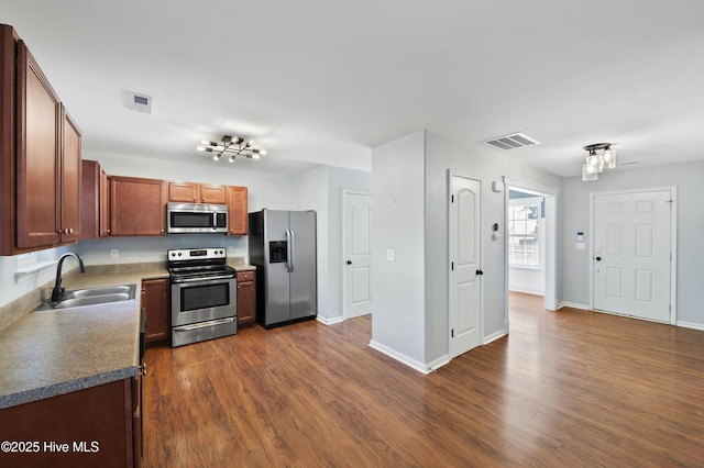 kitchen with sink, dark wood-type flooring, and appliances with stainless steel finishes