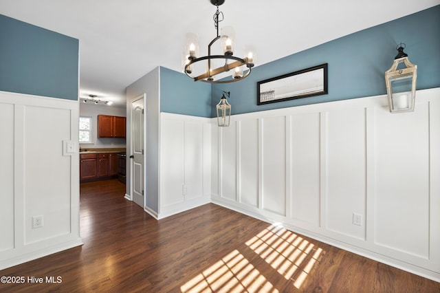 6507 Rustling Leaves Way, Wilmington, NC 28409 - unfurnished dining area featuring a decorative wall, a chandelier, dark wood-type flooring, and wainscoting