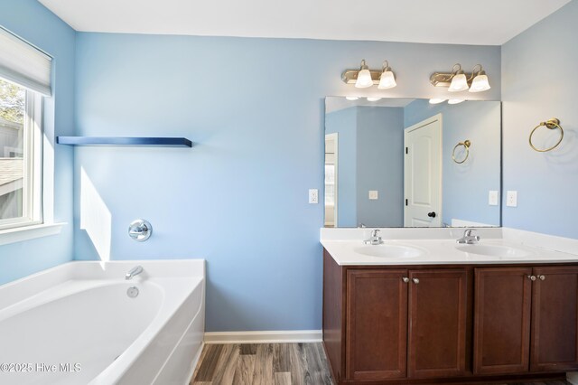 6507 Rustling Leaves Way, Wilmington, NC 28409 - full bath featuring wood finished floors, a bath, double vanity, and baseboards