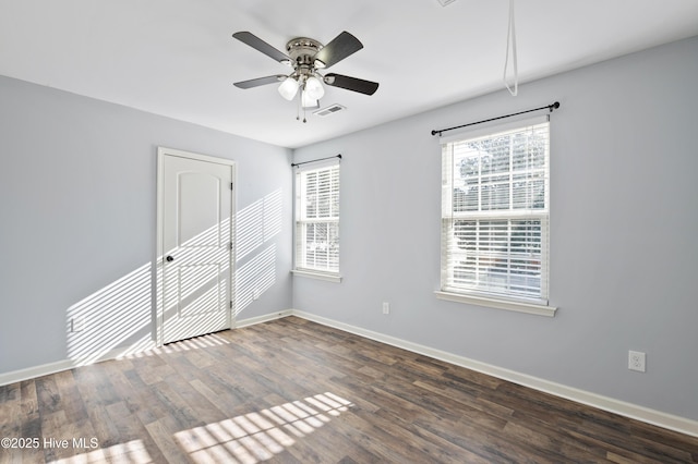 spare room with dark wood-type flooring and ceiling fan