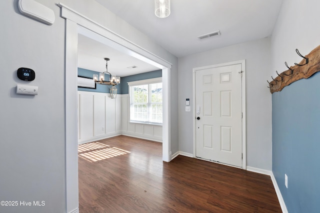 foyer featuring dark hardwood / wood-style flooring and a notable chandelier