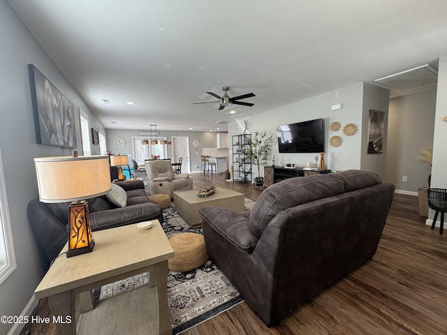 living room featuring recessed lighting, dark wood-style flooring, baseboards, and ceiling fan with notable chandelier