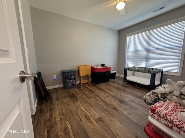 home office featuring ceiling fan, dark wood-type flooring, visible vents, and baseboards