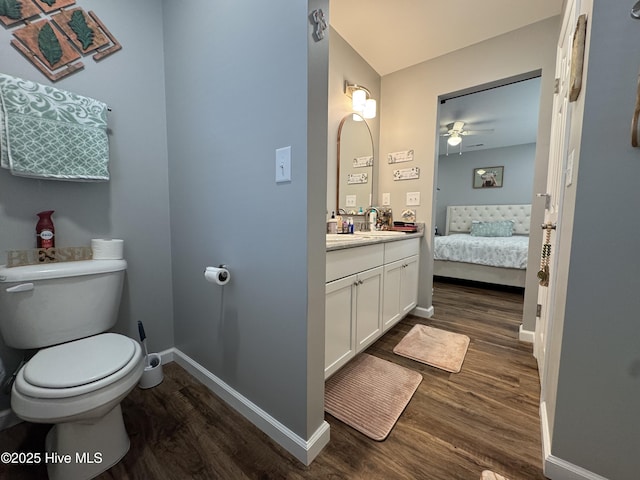 bathroom featuring vanity, wood finished floors, toilet, and baseboards