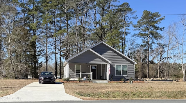 bungalow featuring covered porch and a front lawn