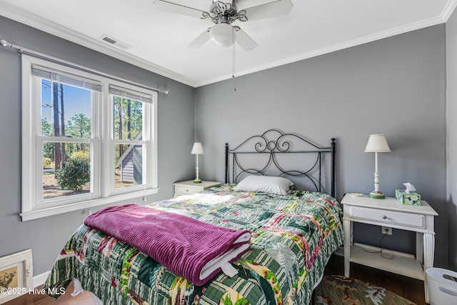 bedroom with crown molding, ceiling fan, baseboards, visible vents, and dark wood finished floors