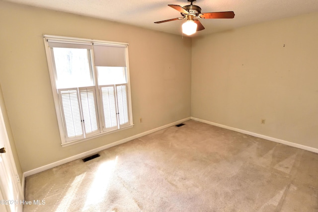 carpeted empty room featuring visible vents and baseboards