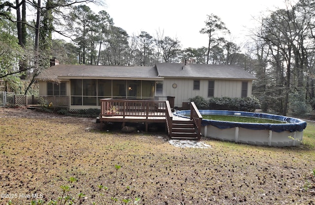 back of house with a deck, a covered pool, a sunroom, and a chimney