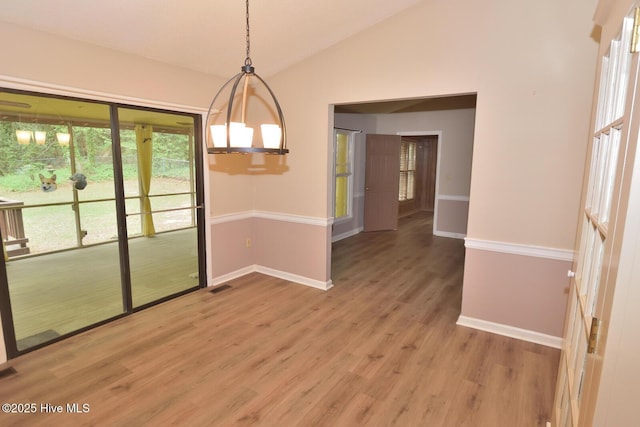 unfurnished dining area with visible vents, light wood finished floors, baseboards, and vaulted ceiling