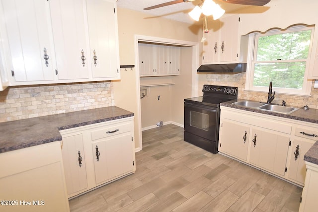 kitchen featuring a ceiling fan, dark countertops, black electric range oven, under cabinet range hood, and a sink