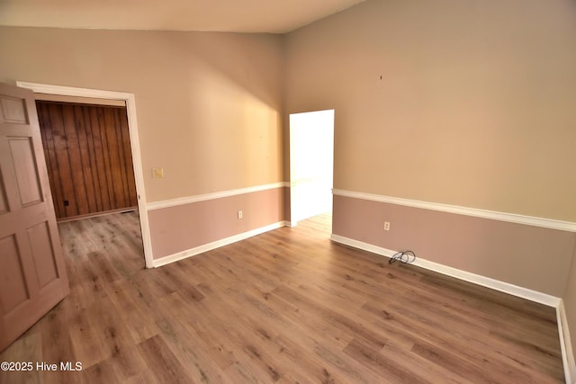 empty room with baseboards and wood finished floors
