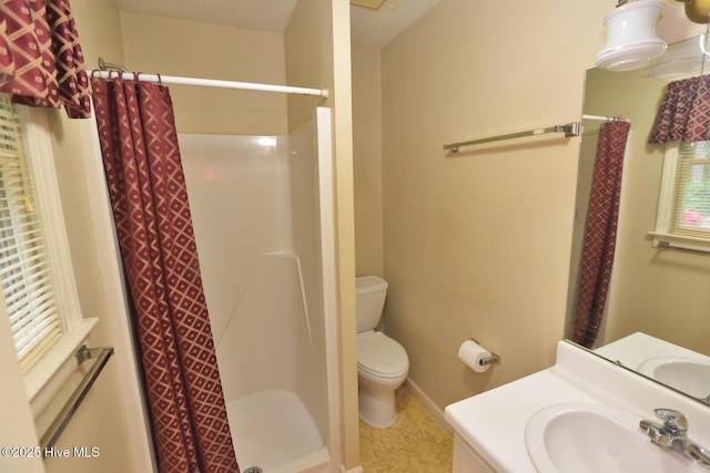 bathroom featuring a shower stall, vanity, baseboards, and toilet