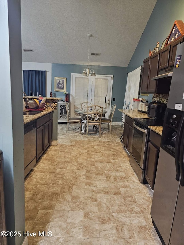 kitchen featuring sink, dark brown cabinets, stainless steel appliances, light stone counters, and vaulted ceiling