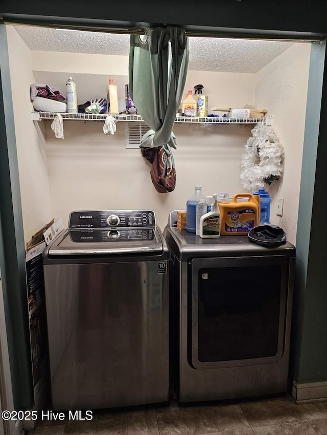 laundry room with washer and dryer and a textured ceiling