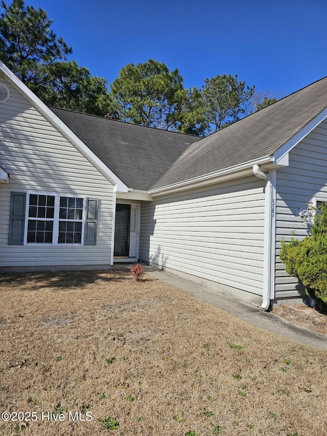 property entrance with a lawn