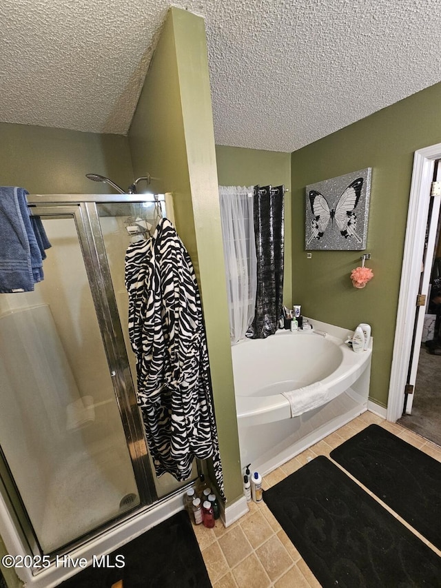 bathroom featuring separate shower and tub, tile patterned floors, and a textured ceiling