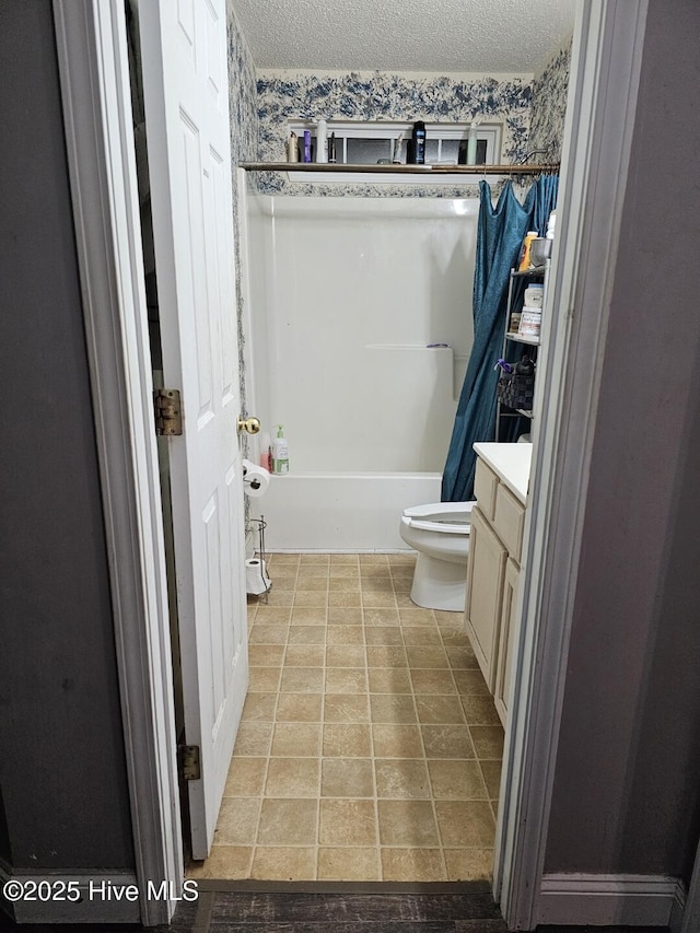 full bathroom with vanity, shower / bath combo, a textured ceiling, and toilet