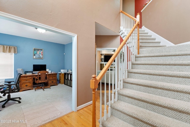 stairway featuring wood finished floors and baseboards