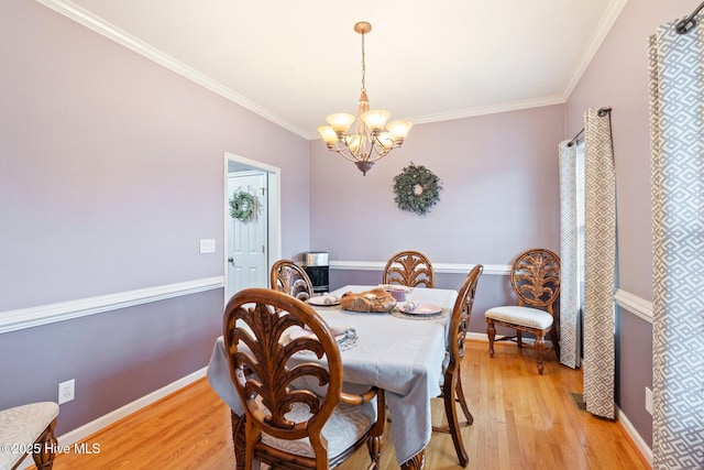 dining space with light wood-style floors, baseboards, and crown molding