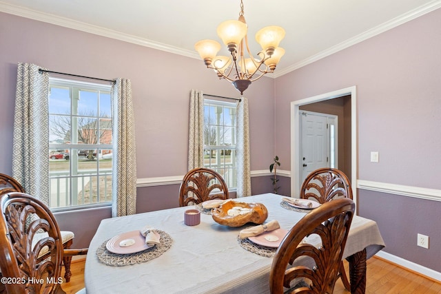 dining space featuring a chandelier, a wealth of natural light, ornamental molding, and wood finished floors