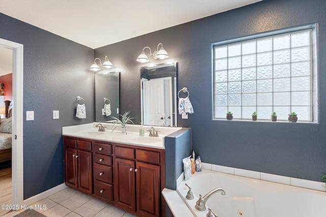 ensuite bathroom with a textured wall, a sink, a whirlpool tub, and double vanity