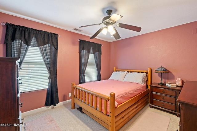 bedroom with a ceiling fan, light carpet, visible vents, and baseboards