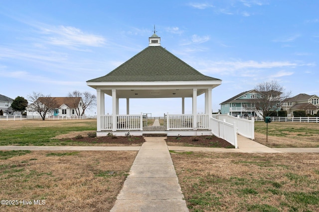 view of community featuring fence, a gazebo, and a lawn