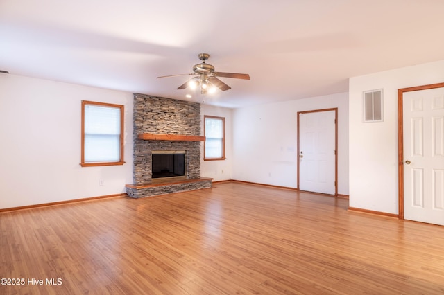 unfurnished living room featuring light wood finished floors, baseboards, a fireplace, and visible vents