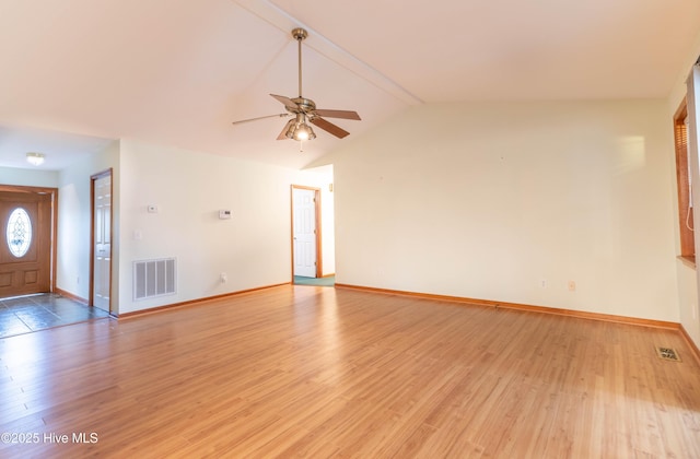 unfurnished living room with light wood-type flooring, baseboards, visible vents, and vaulted ceiling